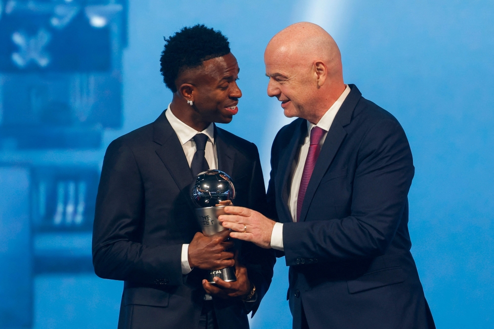Brazilian forward Vinicius Junior (L) receives the Best Player trophy from FIFA President Gianni Infantino in Doha on Tuesday. — AFP 