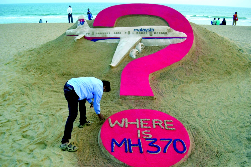 Creating a sand sculpture of the missing Malaysia Airlines flight MH370