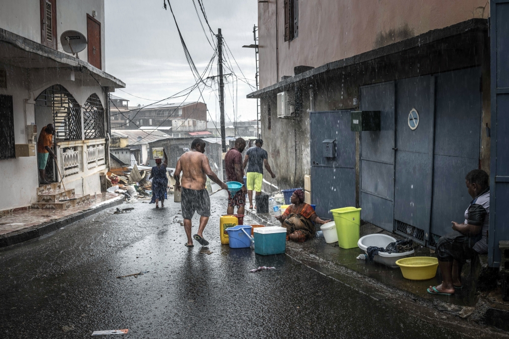 With the taps still dry following Cyclone Chido, residents collect water during a downpour in Mamoudzou, capitol of the French territory of Mayotte, on Thursday, Dec. 19, 2024. (Sergey Ponomarev/The New York Times)
