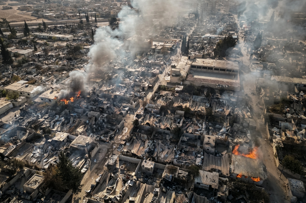 A drone image shows the houses of Alawite Syrian army officers burning in Husseiniyah, south of Damascus, Syria, on Tuesday, Dec. 17, 2024. (Nicole Tung/The New York Times)