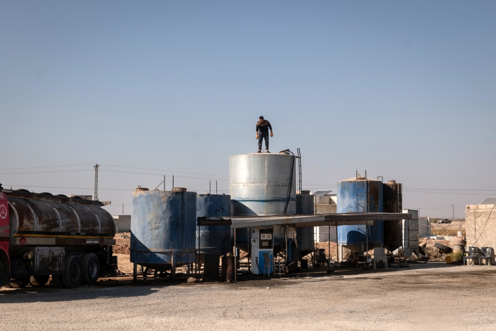 A man stood atop oil vessels by the side of the road in Al Rai, Syria, on Wednesday, October 30, 2024.  (Nicole Tung/The New York Times)