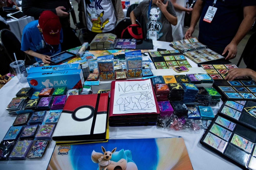 (FILES) People trade Pokemon cards during the first day of the 2019 Pokemon World Championships at the Washington Convention Center August 16, 2019, in Washington, DC. With more than 60 million downloads and nearly 180 million dollars (171 million euros) generated worldwide since the end of October 2024, the mobile game adaptation of Pok駑on cards has enjoyed global success, not far from the records of its predecessor. 