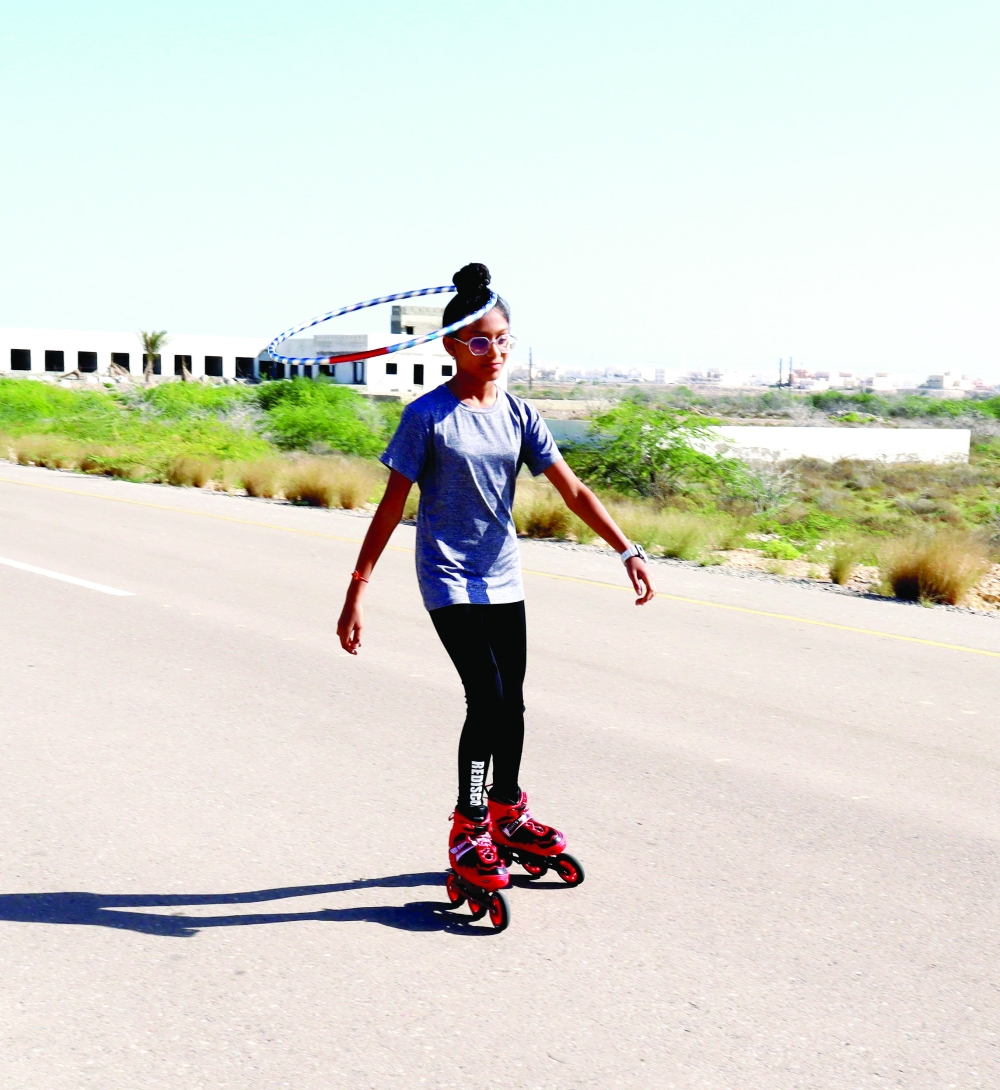 Shivanya does roller skating skating while hula hooping around a hair bun

