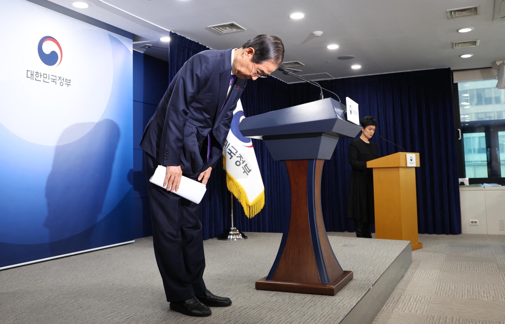 South Korea Prime Minister and acting President Han Duck-soo bows as he delivers his address to the nation at the Government Complex in Seoul. — AFP 