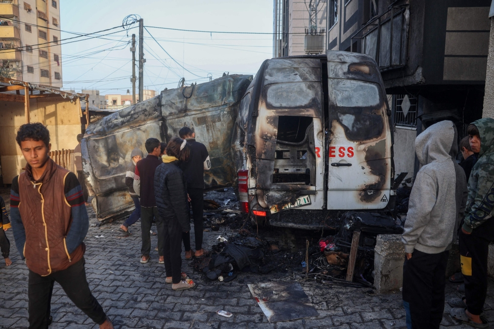 Children check the site of an Israeli strike on a broadcast truck, in the Nuseirat refugee camp in central Gaza. — AFP