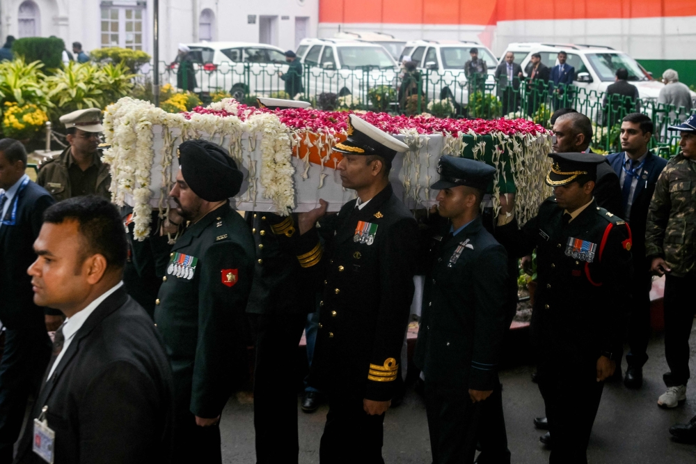 Officers carry the mortal remains of India's late former Prime Minister Manmohan Singh, at the All India Congress Committee (AICC) headquarters in New Delhi