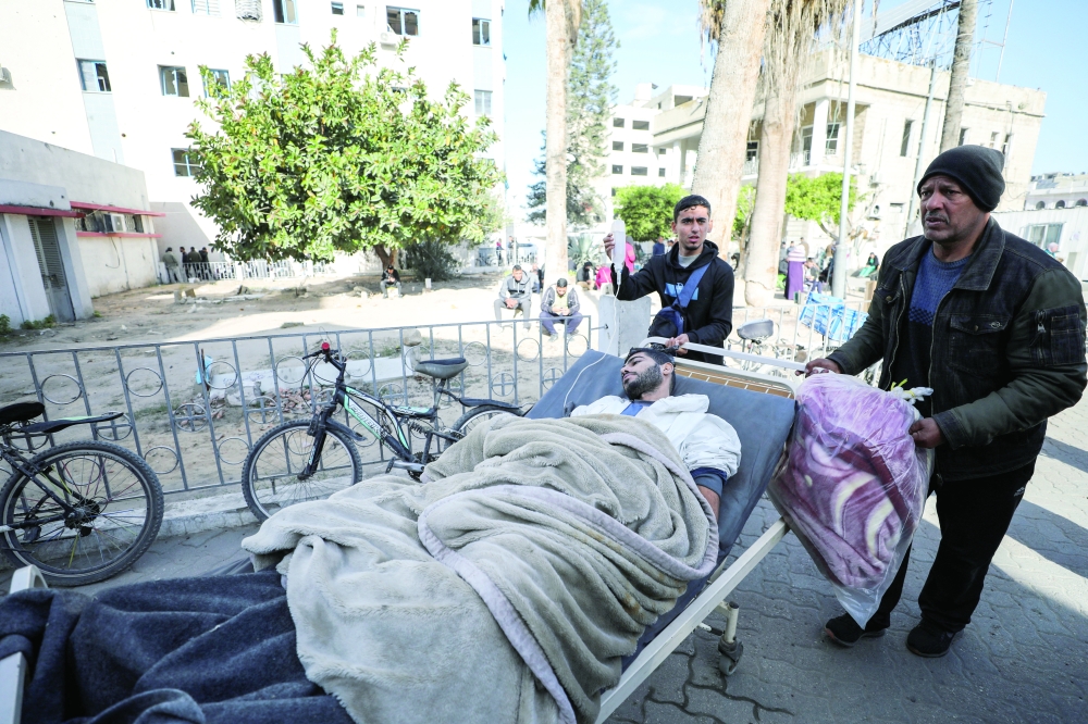 Wounded Palestinians evacuated from Kamal Adwan hospital in northern Gaza, after Israeli forces raided the medical facility, arrive at Al-Ahli al-Arabi hospital. — Reuters