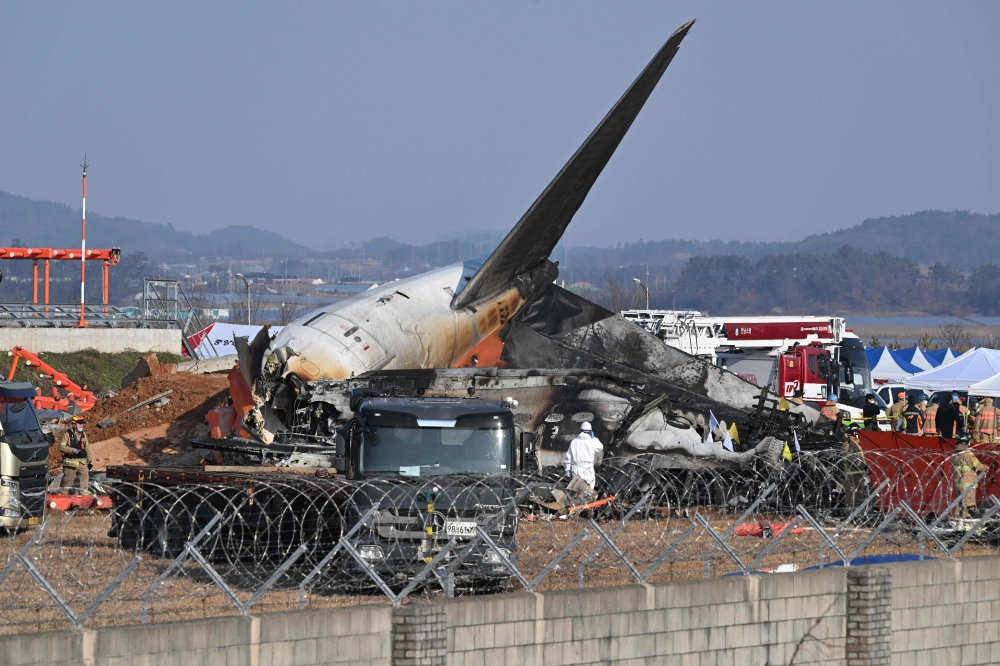 Firefighters and rescue personnel work near the wreckage of a Jeju Air Boeing 737-800 series aircraft after the plane crashed and burst into flames at Muan International Airport in South Jeolla Province on Sunday.