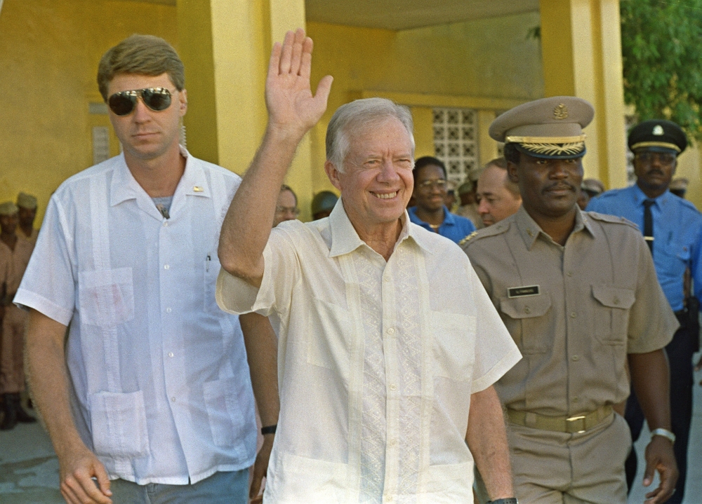 Jimmy Carter (C) waves after meeting September 22, 1990 in Port-au-Prince 