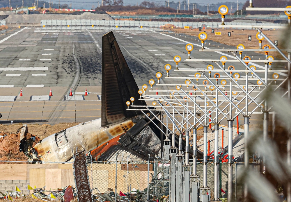 The wrecked tail section of the Jeju Air Boeing 737-800 aircraft is seen at the end of the runway at Muan International Airport 