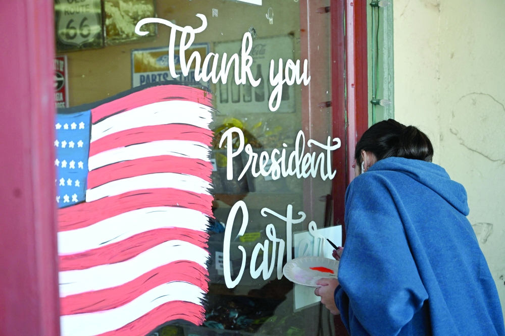 A mural in memory of Jimmy Carter is painted on a storefront at the Jimmy Carter National Historic Park in Plains, Georgia. — AFP