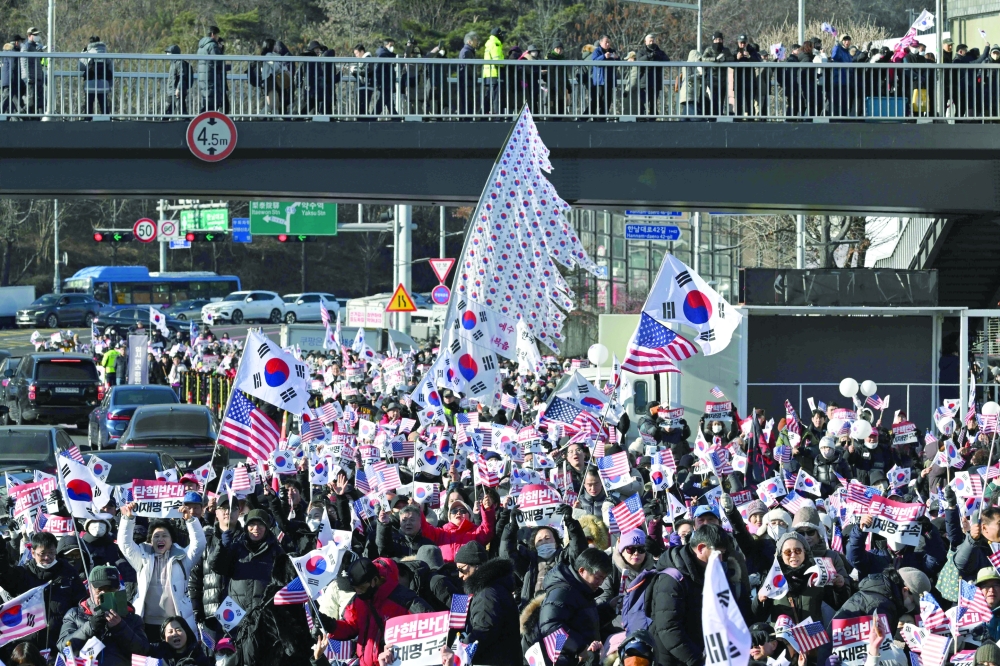 Supporters of impeached South Korea President Yoon Suk Yeol wave flags as they gather near the presidential residence in Seoul. — AFP