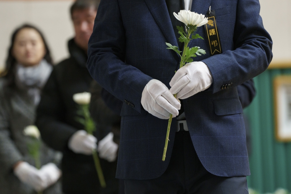Mourners pay their respects at a memorial set up at Muan Sports Park for those killed in Sunday’s plane crash at Muan International Airport in Muan, South Korea, on Monday, Dec. 30, 2024.. (Chang W. Lee/The New York Times)
