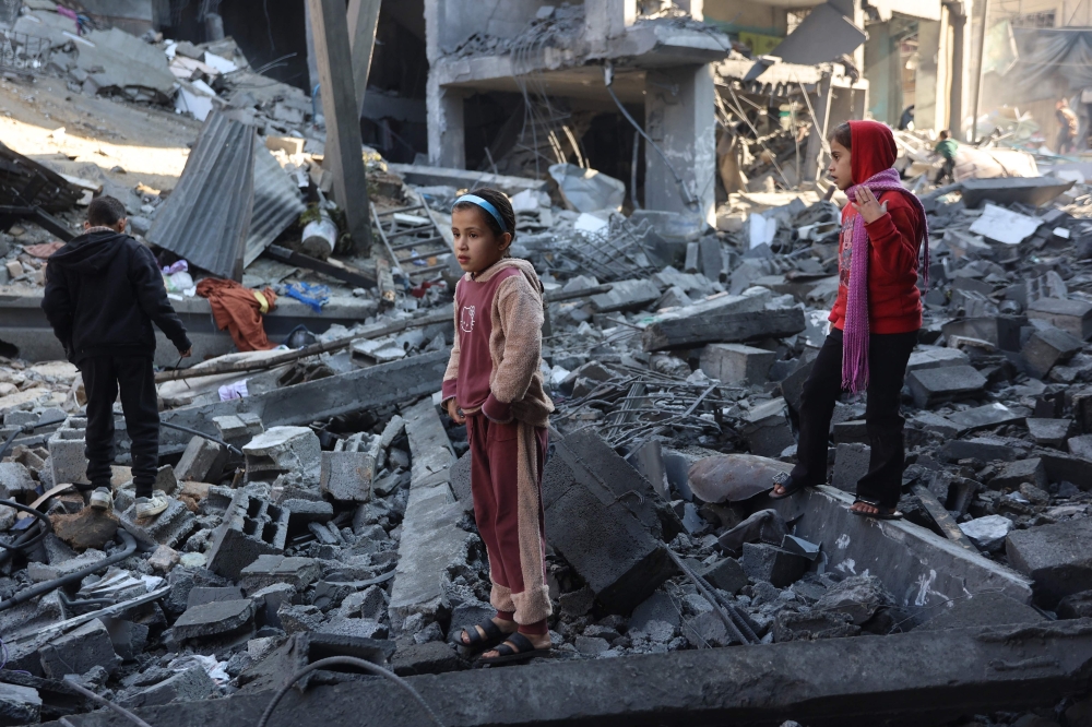 Palestinian children inspect the damage at the site of an Israeli strike the previous night, in Jabalia. — AFP 