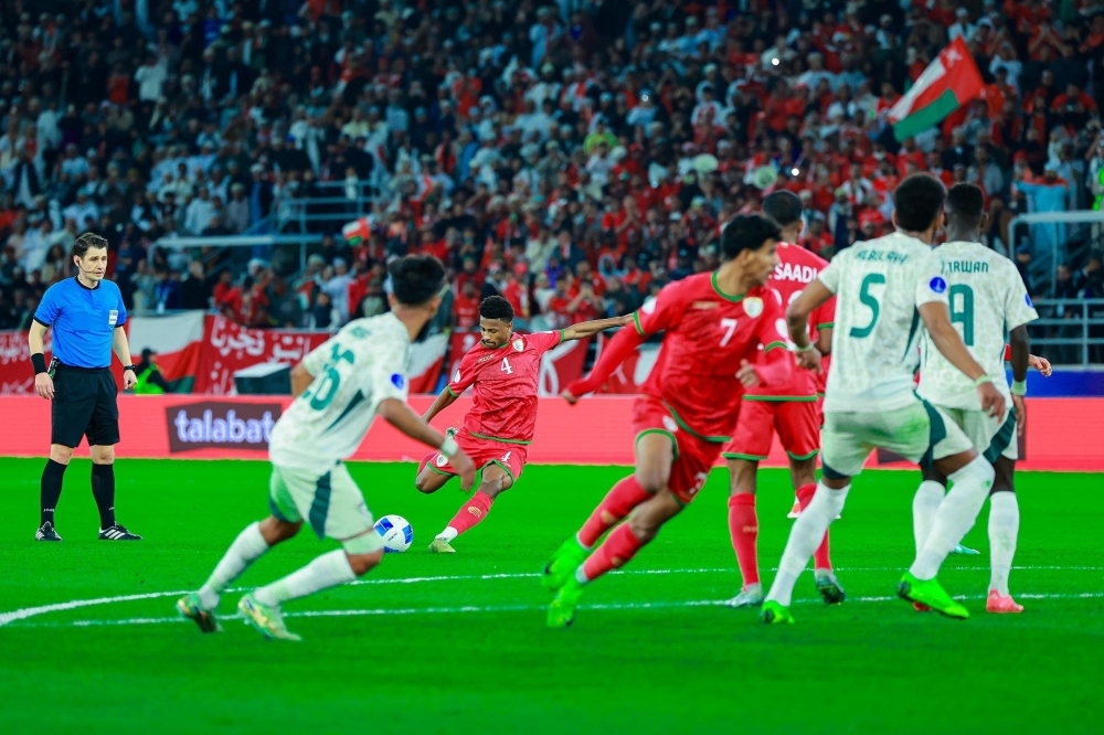Oman's Arshad al Alawi takes the free kick.
