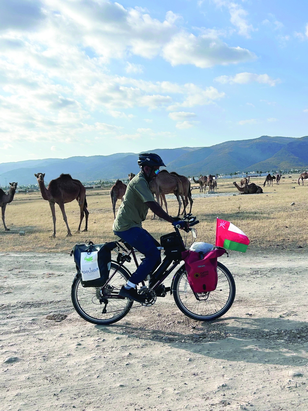 Cyclist Arun Thadagath with camels in the Salalah mountains.jpg