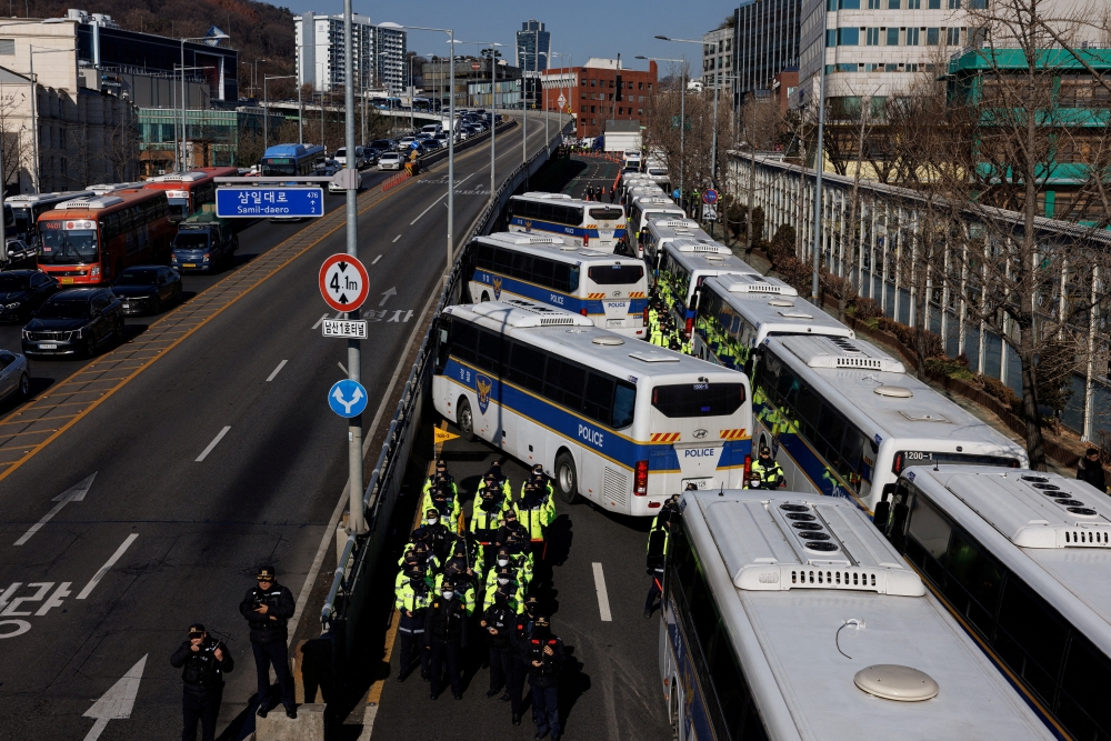 Police stand guard, blocking the road leading to the official residence of impeached South Korean President Yoon Suk Yeol as protesters gather nearby, in Seoul, South Korea, January 4, 2025. REUTERS/Tyrone Siu
