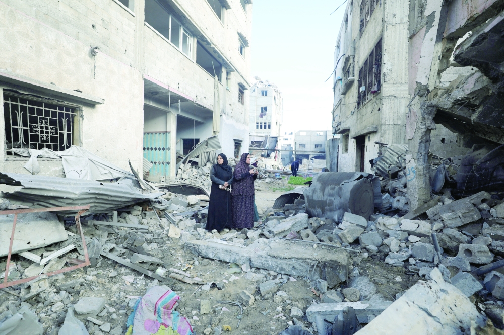 Palestinian women react at the site of an Israeli strike on a house, in Gaza City. — Reuters