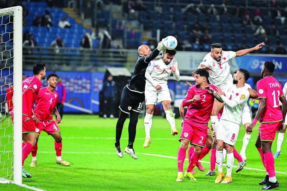 Oman's goalkeeper #18 Faiz al-Rushaidi clears the ball next to Bahrain's forward #07 Ali Madan during the 26th Arabian Gulf Cup final football match between Oman and Bahrain at Jaber al-Ahmad al-Sabah Stadium In Kuwait City on January 4, 2025.  (Photo by YASSER AL-ZAYYAT / AFP)

