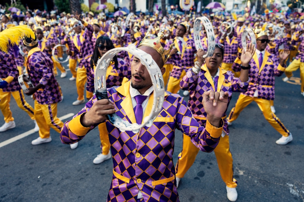 Kaapse Klopse minstrels dance as their troupe moves forward during the annual Kaapse Klopse parade, also known as "Tweede Nuwe Jaar" (second New Year), in Cape Town on January 4, 2025.   Thousands of colourfully costumed minstrels paraded through Cape Town Saturday in an exuberant century-old carnival rooted in the South African city's history of slavery that drew large crowds of spectators. In glitzy uniforms matched with flashy hats, parasols and face paint, the marchers walked and danced through the city's historic centre in an annual event that an organiser said had grown to become the biggest such parade on the continent. (Photo by GIANLUIGI GUERCIA / AFP)

