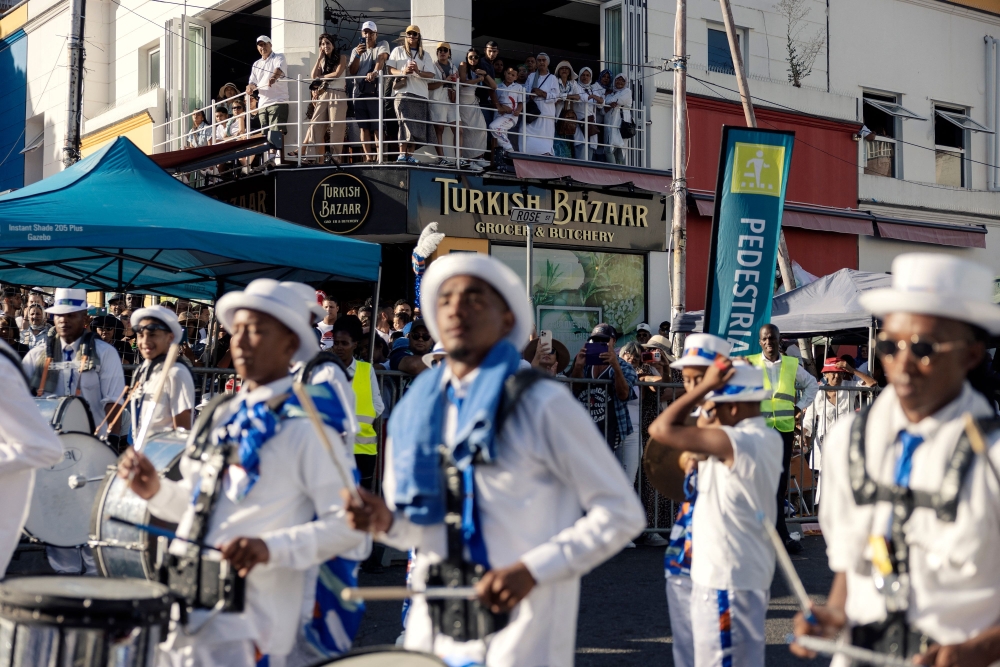 Kaapse Klopse minstrels dance as their troupe moves forward during the annual Kaapse Klopse parade, also known as "Tweede Nuwe Jaar" (second New Year), in Cape Town on January 4, 2025.   Thousands of colourfully costumed minstrels paraded through Cape Town Saturday in an exuberant century-old carnival rooted in the South African city's history of slavery that drew large crowds of spectators. In glitzy uniforms matched with flashy hats, parasols and face paint, the marchers walked and danced through the city's historic centre in an annual event that an organiser said had grown to become the biggest such parade on the continent. (Photo by GIANLUIGI GUERCIA / AFP)

