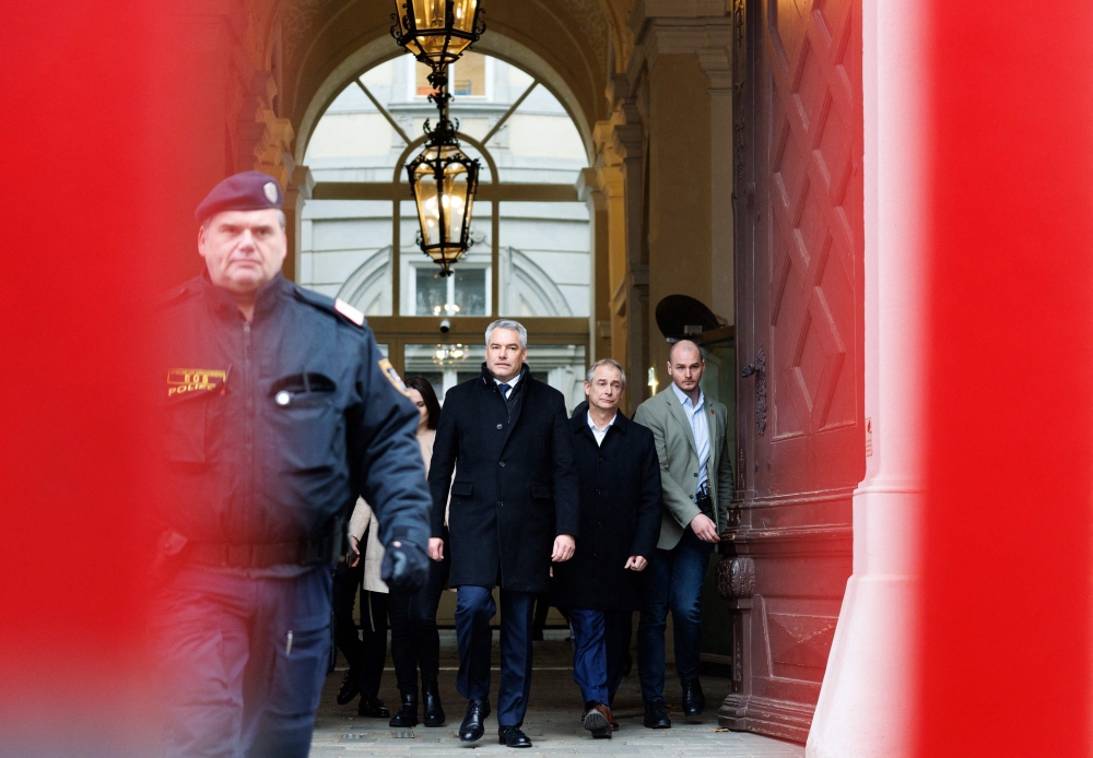 Austrian Chancellor and leader of Austrian People's Party (OeVP) Karl Nehammer (C) in on his way to the Presidential Chancellery in Vienna. — AFP 