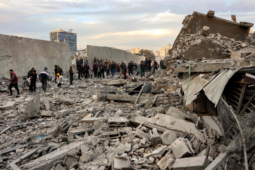 People and first responders inspect the rubble 