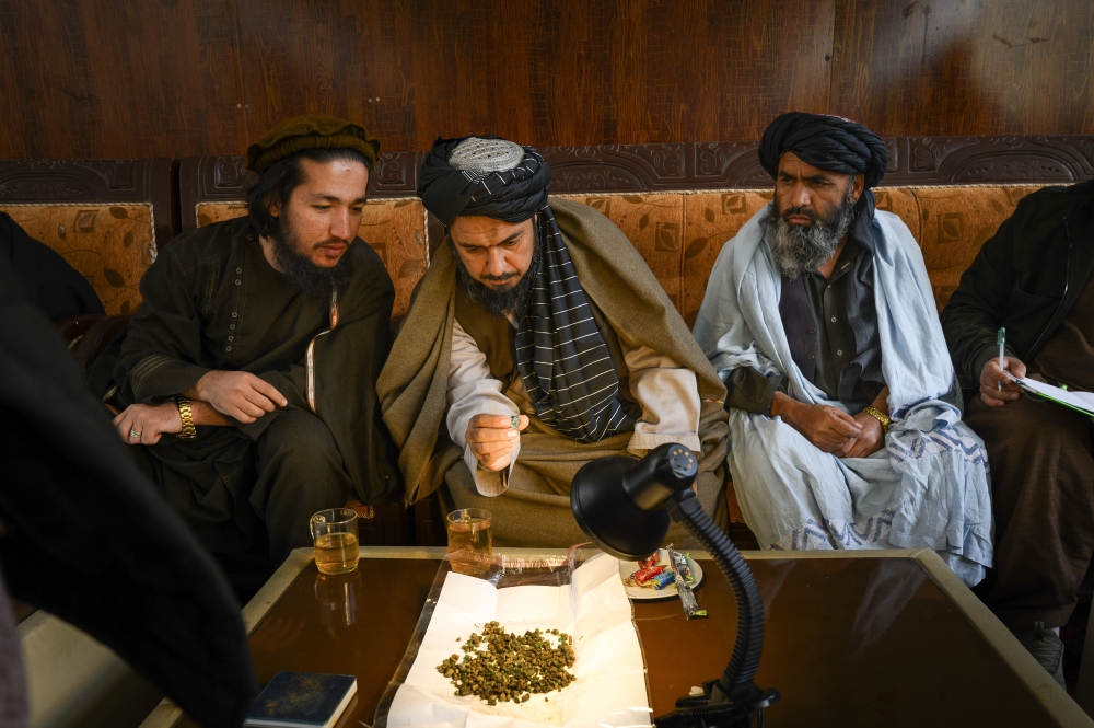 Provincial officials inspect an emerald during a weekly auction in Bazarak, the capital of Panjshir Province in Afghanistan, Dec. 10, 2024. (Elise Blanchard/The New York Times)