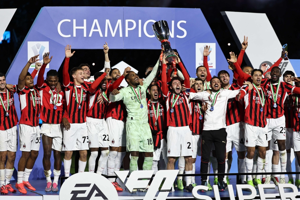 AC Milan's players celebrate with the trophy after winning the Italian Super Cup final football match between Inter Milan and AC Milan at the Al-Awwal Park in Riyadh on January 6, 2025. (Photo by FADEL SENNA / AFP)

