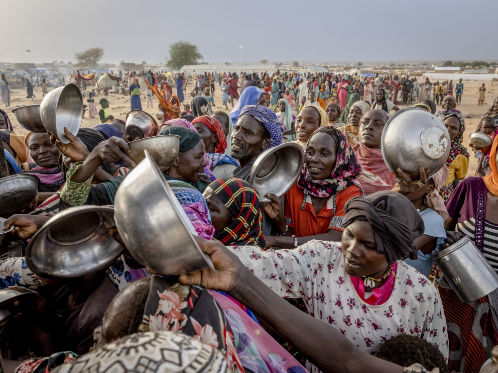 A crowd of Sudanese refugees from the Darfur region jostle in line to receive food during an impromptu aid distribution on the outskirts of Adre refugee camp, Chad, July 8, 2024. (Ivor Prickett/The New York Times)