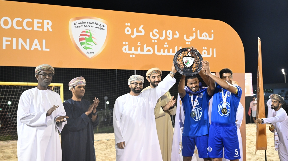 Al Amerat Club players receive the trophy. -- Abdulwahid al Hamadani