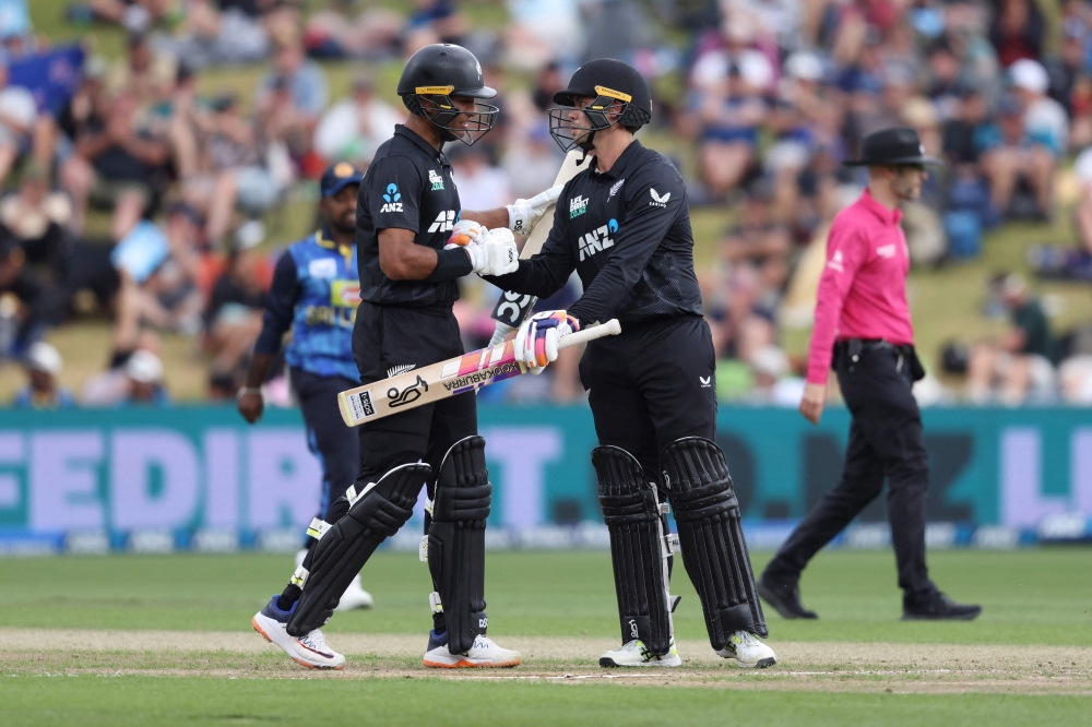 New Zealand's Mark Chapman (front R) celebrates his 50 runs with teammate Rachin Ravindra during the second one-day international cricket match between New Zealand and Sri Lanka at Seddon Park in Hamilton on January 8, 2025. (Photo by Michael Bradley / AFP)

