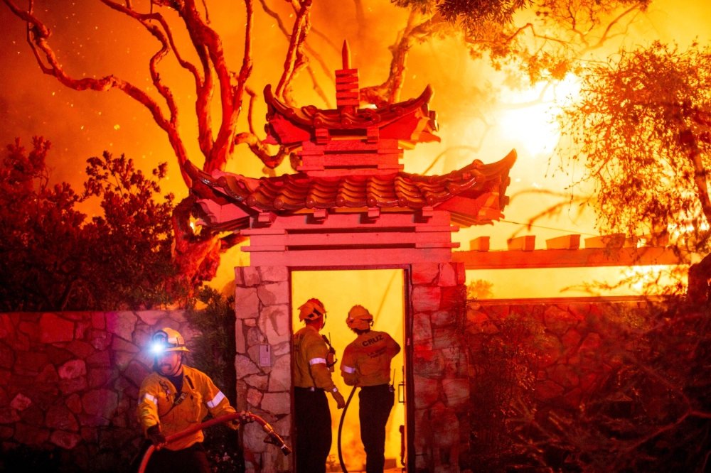 Firefighters battle the Palisades Fire as it burns during a windstorm on the west side of Los Angeles, California. - Reuters