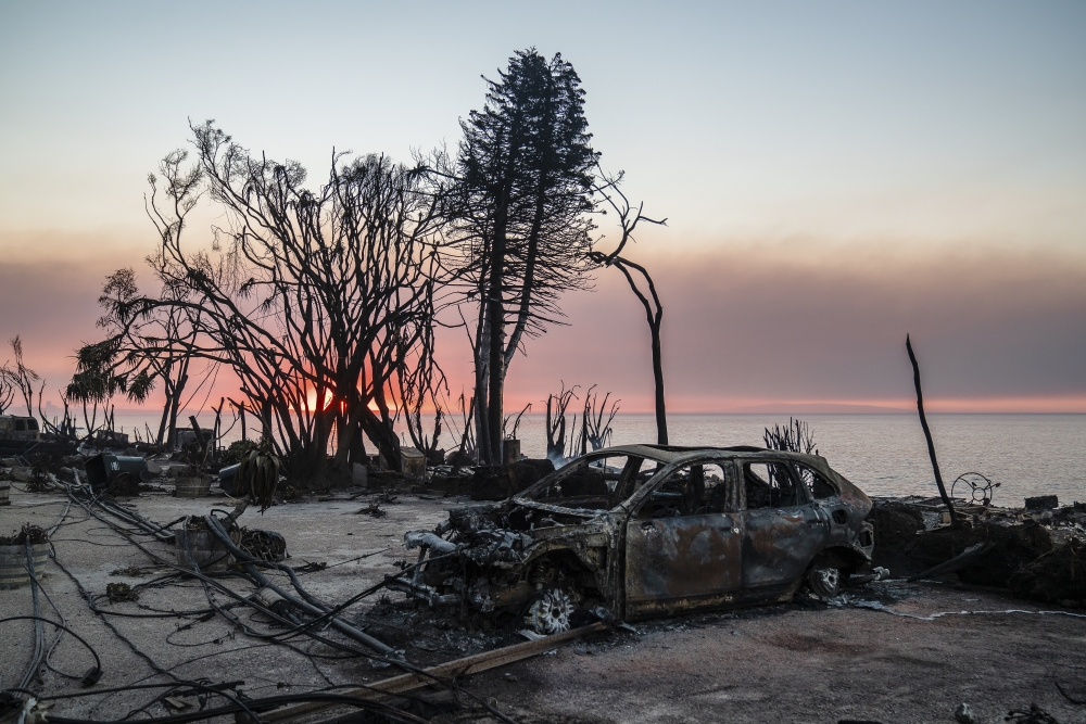 Downed utility lines and a car burned by the Palisades fire along the water at sunrise in Malibu, Calif., on Friday, Jan. 10, 2025. (Ariana Drehsler/The New York Times)