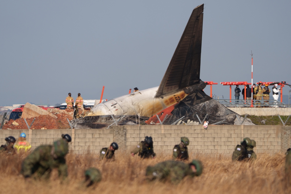 Military personnel search for debris around the Jeju Air passenger jet crash in Muan, South Korea, Dec. 29, 2024. (Chang W. Lee/The New York Times)