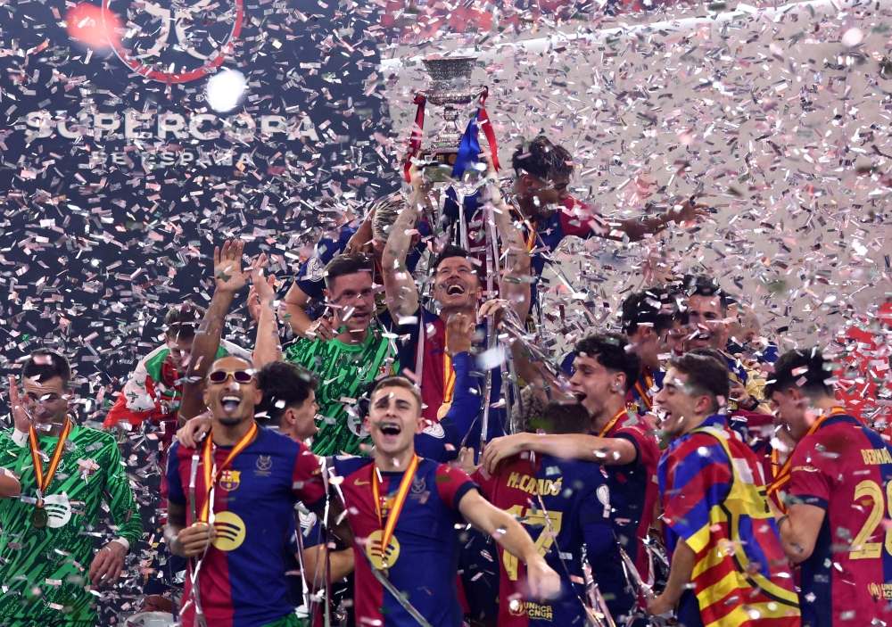 Robert Lewandowski celebrates with the trophy and teammates after winning the Spanish Super Cup. — Reuters