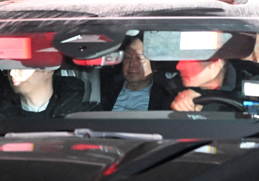 Impeached South Korea President Yoon Suk Yeol (C) leaves the complex building housing the Corruption Investigation Office for High-ranking Officials (CIO) in Gwacheon 