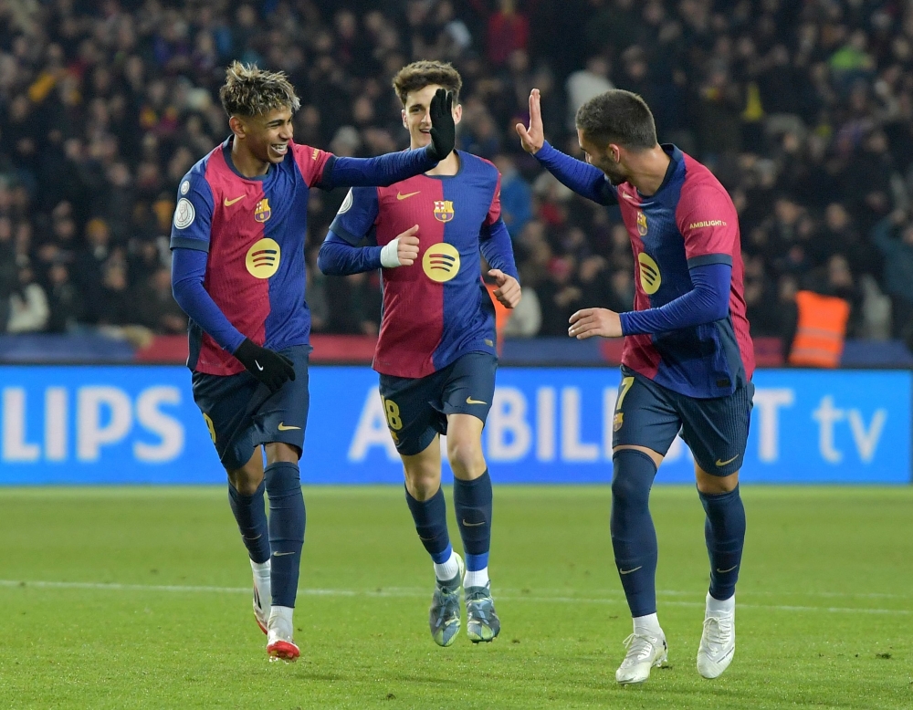 Barcelona's Spanish forward #19 Lamine Yamal (L) celebrates with teammates scoring his team's fifth goal during the Spanish Copa del Rey (King's Cup) last 16 first leg football match between FC Barcelona and Real Betis at the Estadi Olimpic Lluis Companys in Barcelona on January 15, 2025. (Photo by MANAURE QUINTERO / AFP)

