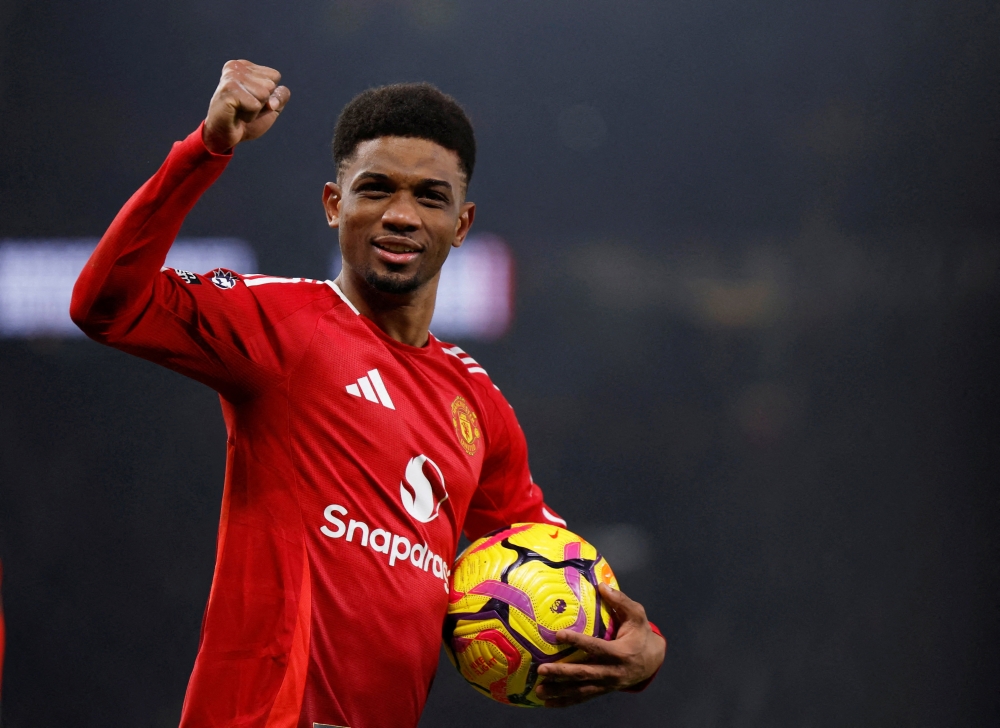 Manchester United's Amad Diallo celebrates with the match ball after scoring a hat-trick 