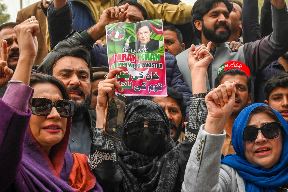 Imran Khan's supporters hold Khan's portrait during a protest in Peshawar