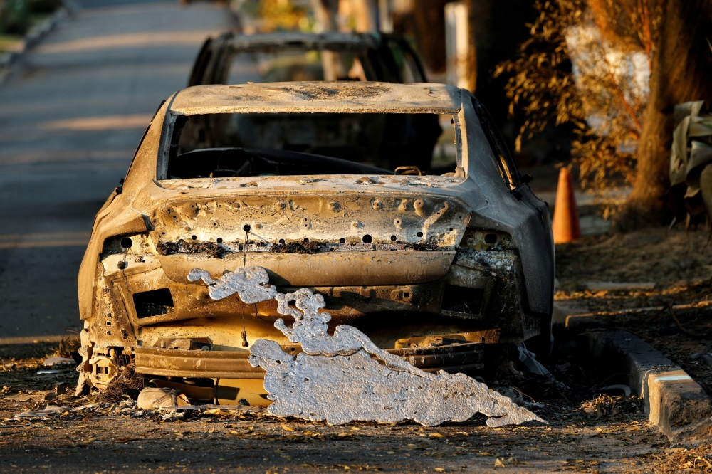 A piece of metal melted in the fire rests against the back of a car burnt by the Palisades Fire, in Pacific Palisades, California, US, on Saturday. - Reuters