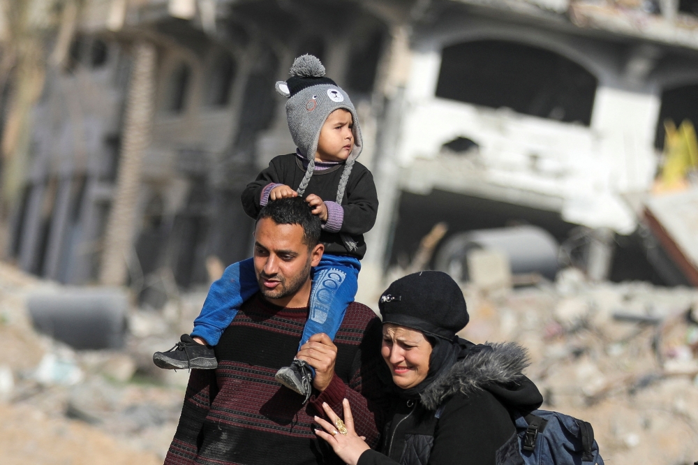 Displaced Palestinians walk past the rubble as they attempt to return to their homes, following a delay in the ceasefire between Israel and Hamas over the hostage list, in the northern Gaza Strip, January 19, 2025. REUTERS/Dawoud Abu Alkas     TPX IMAGES OF THE DAY