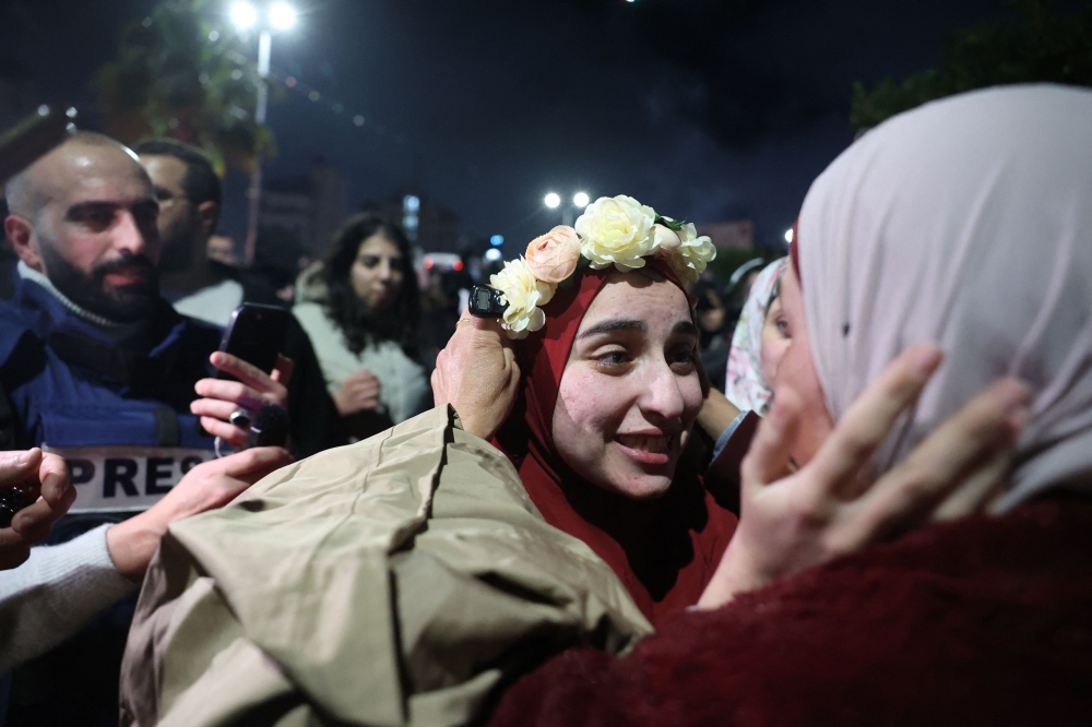 A Palestinian prisoner is welcomed by a relative upon the arrival of some 90 prisoners set free by Israel in the early hours of January 20