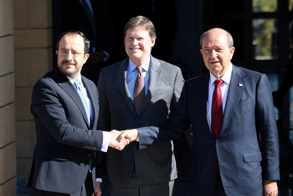 President Nikos Christodoulides (L), and Turkish Cypriot leader Ersin Tatar (R) shake hands after a meeting in the presence of UN Cyprus representative Colin Stewart (C) in the UN buffer zone in the capital Nicosia. — Reuters 
