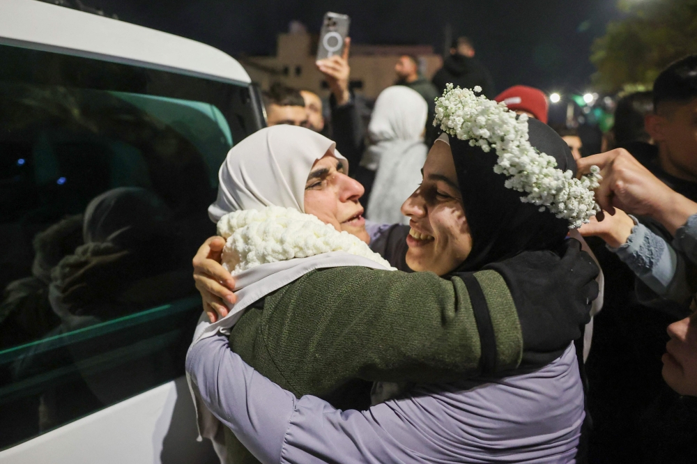 Palestinian prisoner Baraah Fuqaha (R), is welcomed by relatives upon the arrival of some 90 prisoners set free, in the West Bank. — AFP 