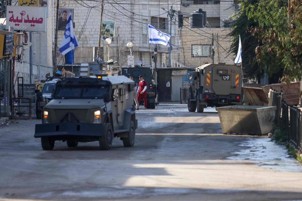 Israeli forces in armoured vehicles conduct a raid in Jenin in the occupied West Bank. — AFP 
