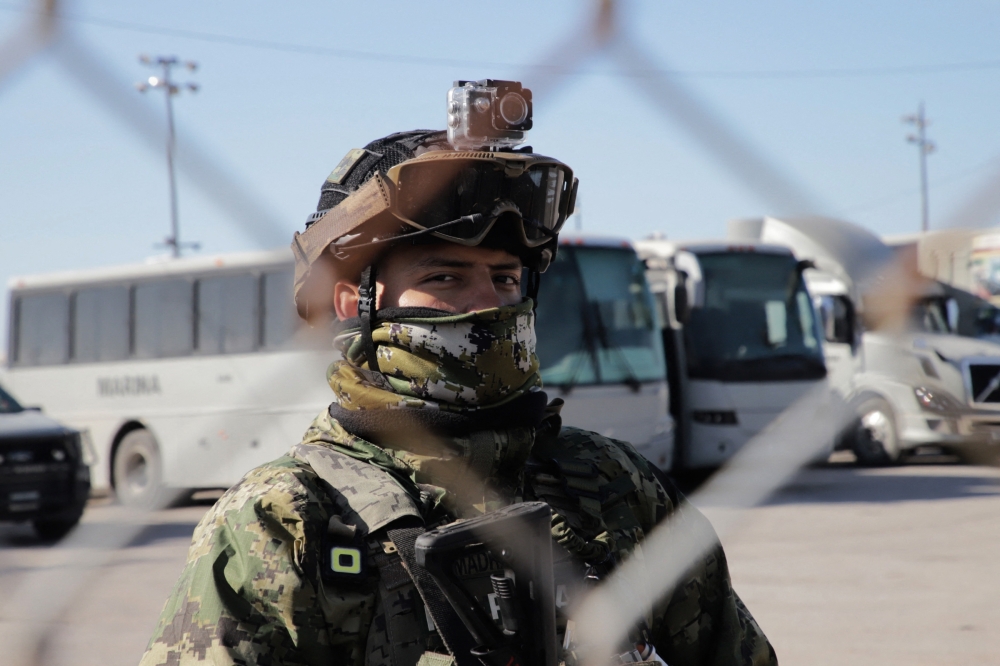 A member of the Mexican Navy stands guard as they begin building a temporary shelter at the US-Mexico border ahead of US President Donald Trump's promised deportations in Matamoros, Tamaulipas state, Mexico. - AFP