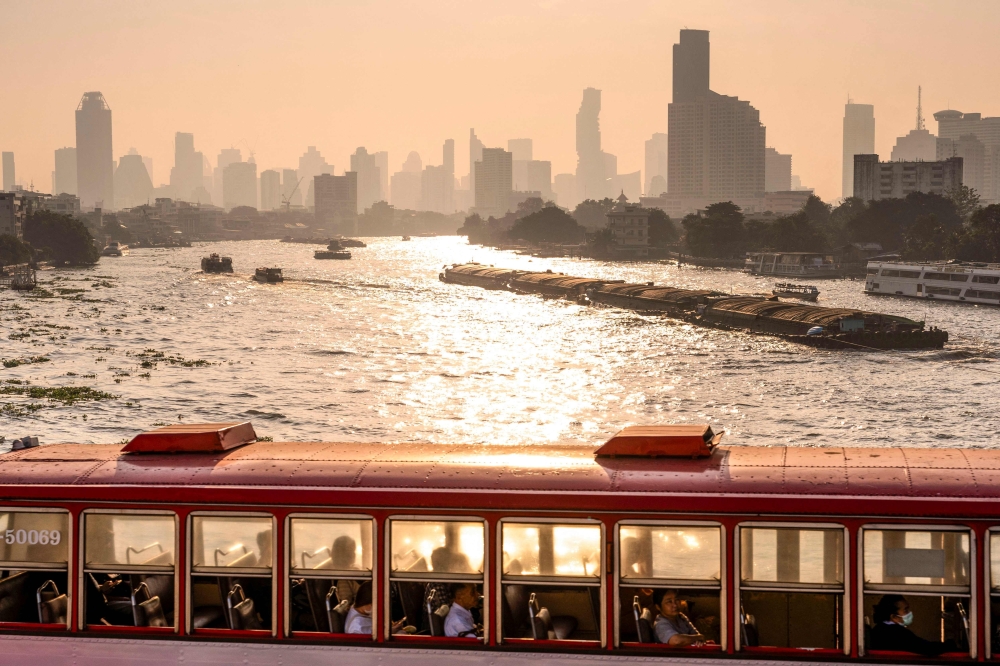 A bus drives on a bridge over the Chao Phraya river amid high air pollution levels in Bangkok. -  AFP
