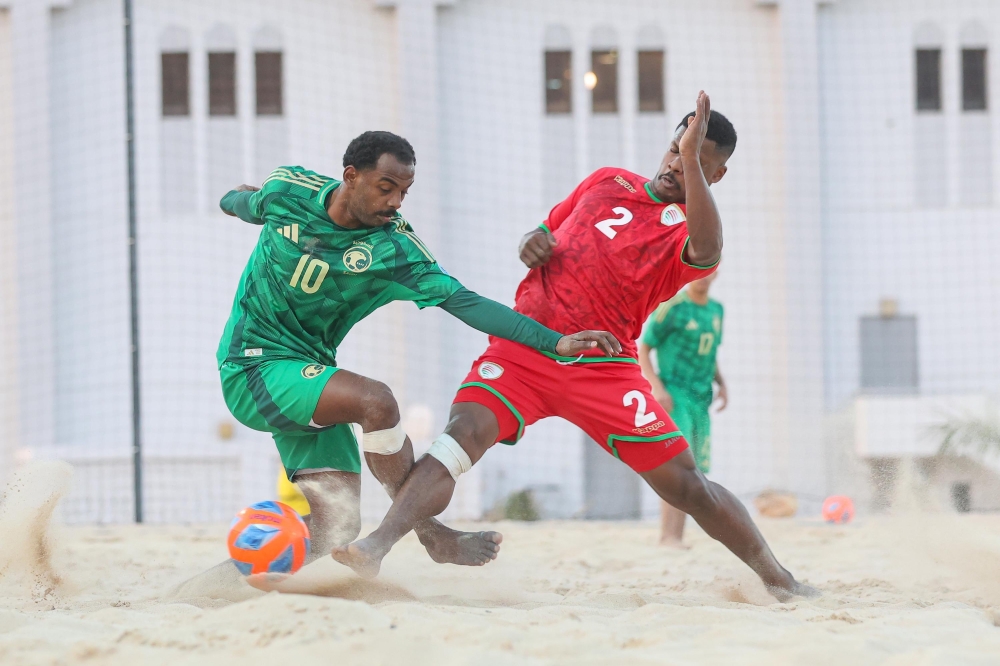 Oman and Saudi players fight for the ball during a friendly