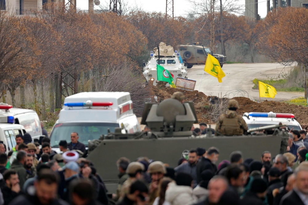 A United Nations Interim Force in Lebanon (UNIFIL) armoured vehicle, an Israeli military jeep, ambulances, as well as a Lebanese army armoured vehicle are parked on either side of an earth barricade in Borj El Mlouk